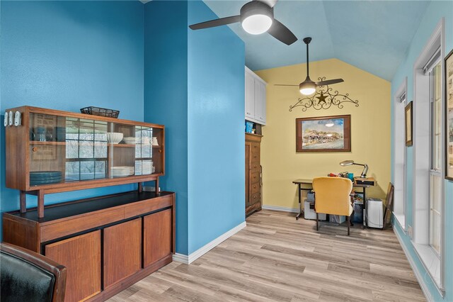 interior space with light wood finished floors, baseboards, a ceiling fan, and vaulted ceiling