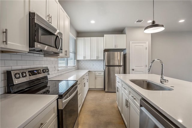 kitchen with stainless steel appliances, sink, and white cabinets