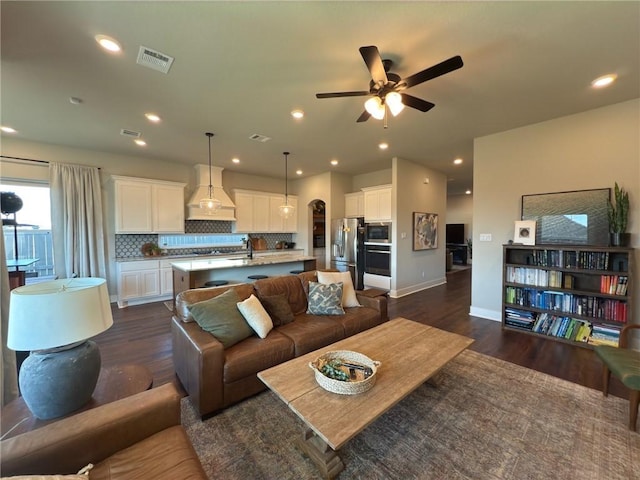 living room featuring ceiling fan, dark hardwood / wood-style flooring, and sink