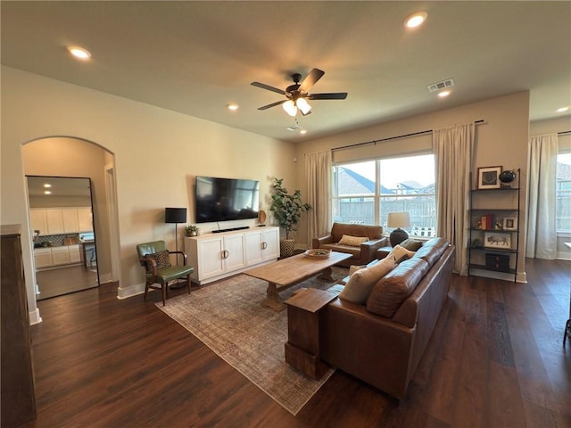 living room featuring ceiling fan and dark wood-type flooring