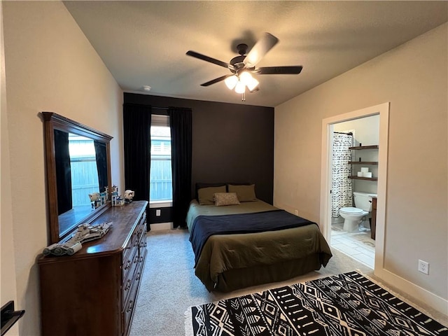 carpeted bedroom featuring ceiling fan and ensuite bath