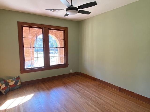 empty room with ceiling fan and hardwood / wood-style floors