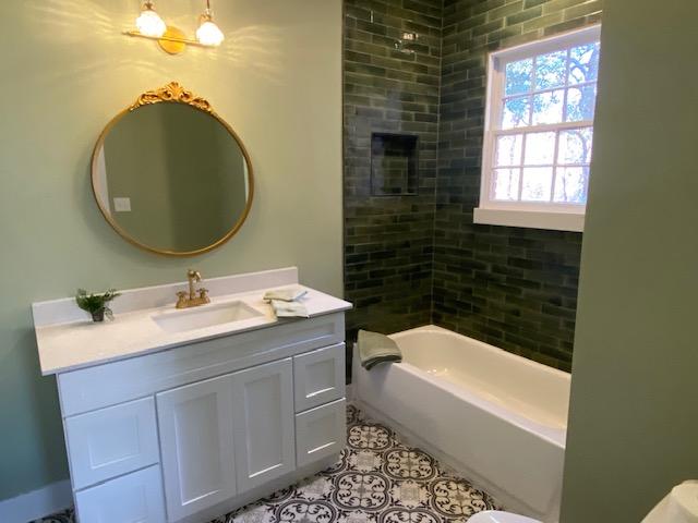 bathroom with vanity and tiled shower / bath