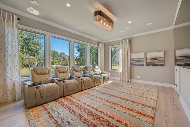 home theater room with light hardwood / wood-style floors and crown molding