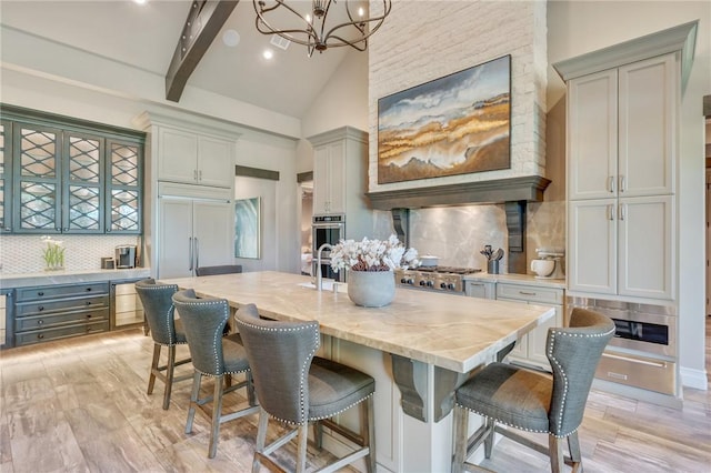 kitchen featuring stainless steel appliances, backsplash, gray cabinets, and hanging light fixtures