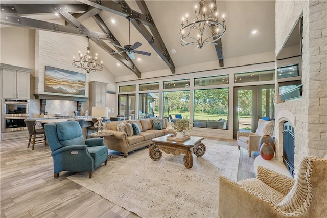 living room with ceiling fan, high vaulted ceiling, beamed ceiling, light hardwood / wood-style floors, and a stone fireplace