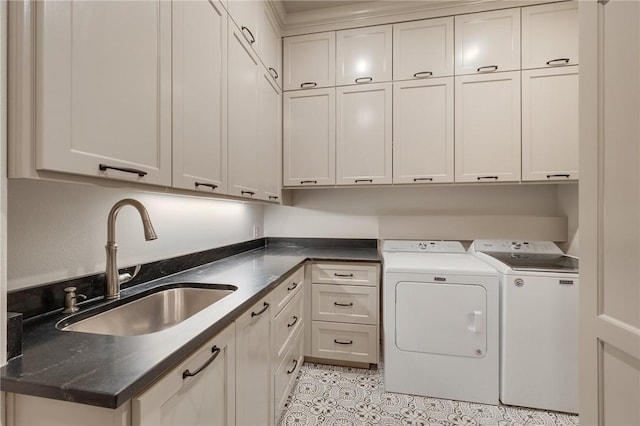 washroom with cabinets, washer and clothes dryer, and sink