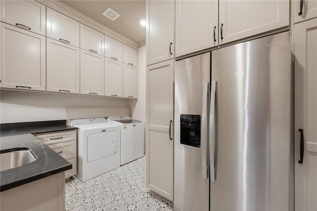 washroom with washer and dryer, cabinets, and sink