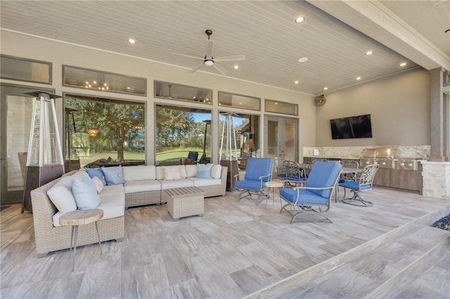 exterior space with outdoor lounge area, ceiling fan, and exterior kitchen