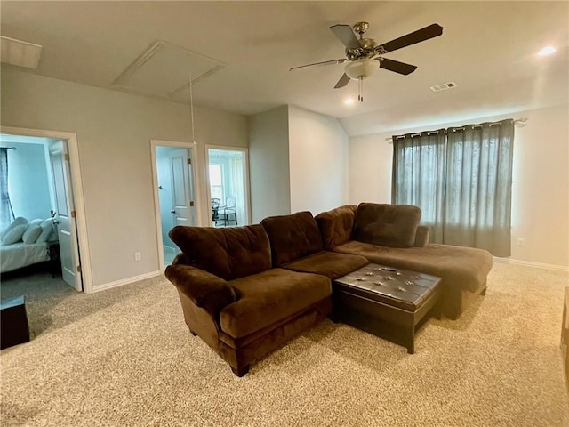 living room featuring visible vents, baseboards, attic access, and light colored carpet