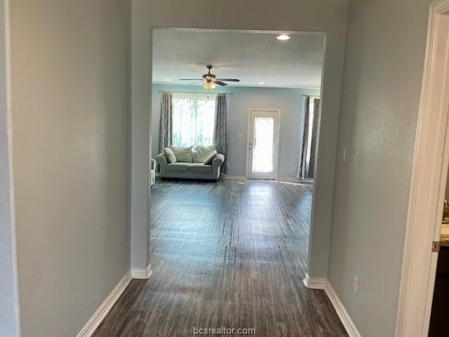 hallway with baseboards, dark wood finished floors, and recessed lighting