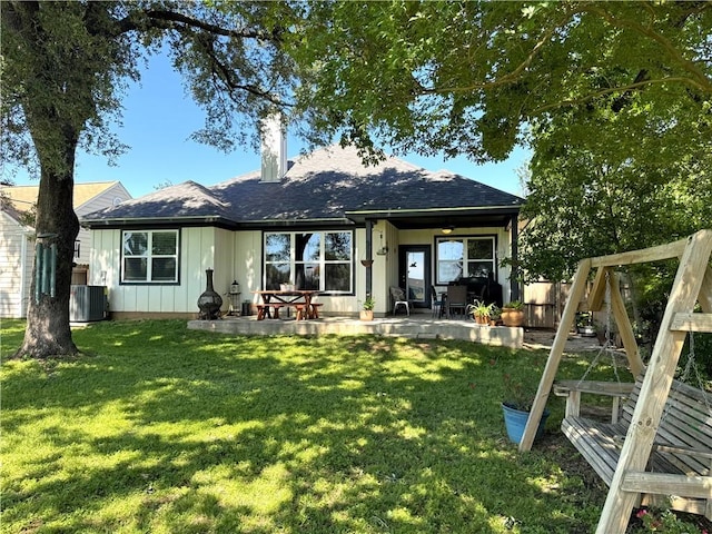 202 N Hearne St, Franklin, TX 77856 - rear view of property featuring cooling unit, a yard, a chimney, board and batten siding, and a patio area