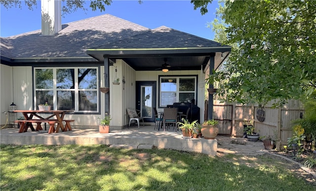 202 N Hearne St, Franklin, TX 77856 - rear view of house featuring fence, a shingled roof, a ceiling fan, and a lawn