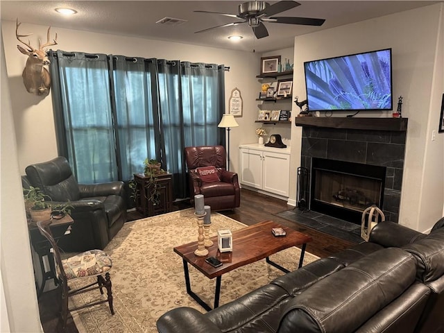 202 N Hearne St, Franklin, TX 77856 - living room with a fireplace, a ceiling fan, dark wood-type flooring, and visible vents