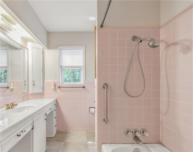 1500 Galde St, College Station, TX 77840 - bathroom featuring vanity, washtub / shower combination, tile walls, wainscoting, and tile patterned flooring