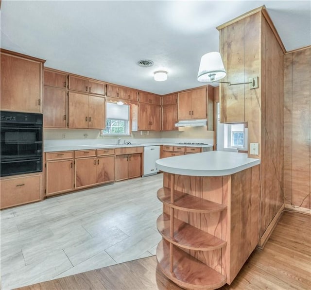1500 Galde St, College Station, TX 77840 - kitchen with light countertops, black oven, dishwasher, a warming drawer, and brown cabinetry