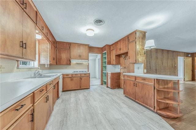 1500 Galde St, College Station, TX 77840 - kitchen with under cabinet range hood, open shelves, white appliances, light countertops, and brown cabinetry