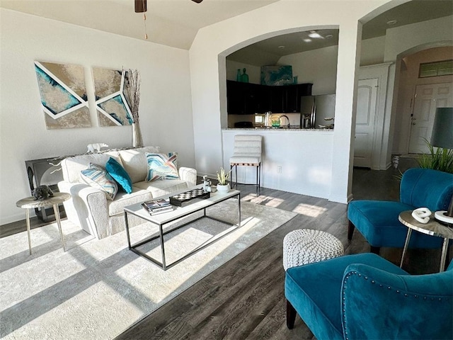 living room featuring dark wood-type flooring, ceiling fan, and sink