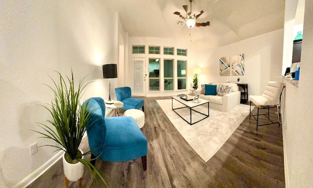 living area with a ceiling fan, baseboards, and wood finished floors