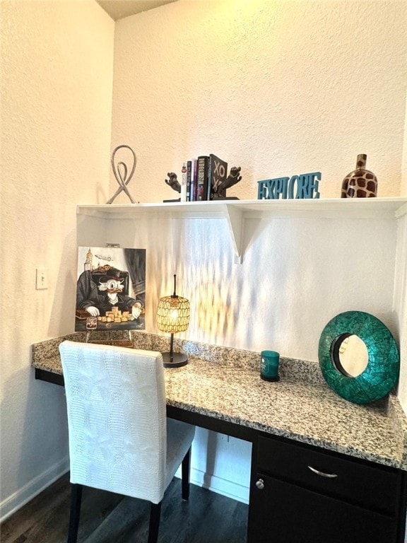 interior details with wood finished floors, built in study area, and baseboards