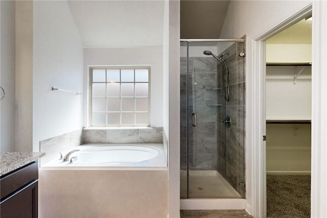 full bath with a shower stall, a spacious closet, vanity, and a bath