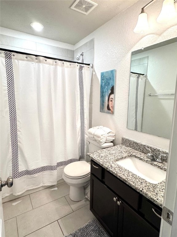 full bathroom with a textured wall, tile patterned flooring, toilet, vanity, and visible vents