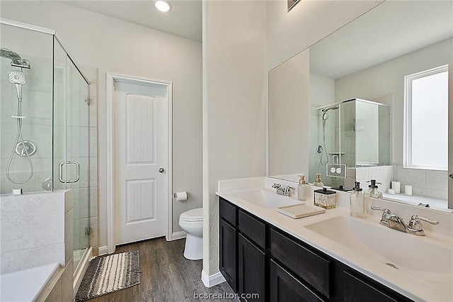 bathroom featuring hardwood / wood-style flooring, vanity, toilet, and an enclosed shower