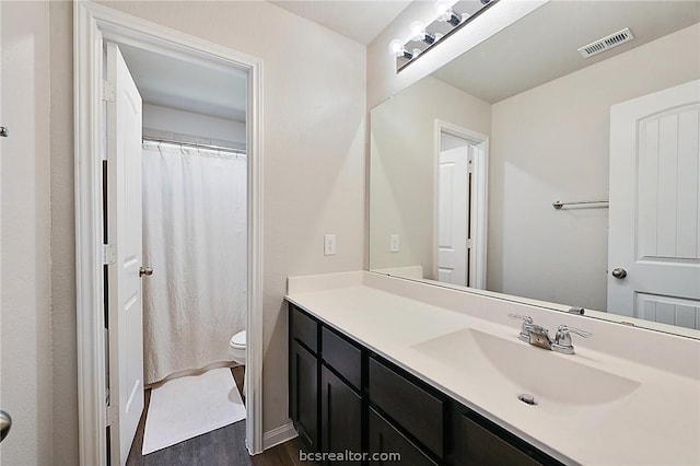 bathroom featuring hardwood / wood-style flooring, vanity, and toilet