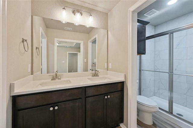 bathroom featuring an enclosed shower, vanity, and toilet