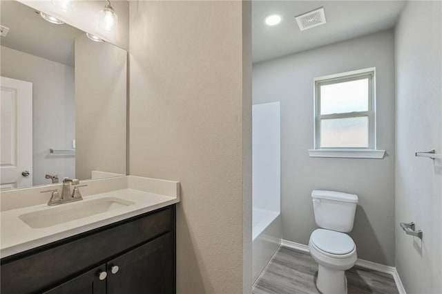 bathroom with vanity, wood-type flooring, and toilet