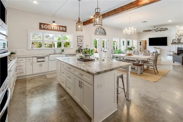 kitchen with white cabinets, a sink, finished concrete flooring, recessed lighting, and tasteful backsplash