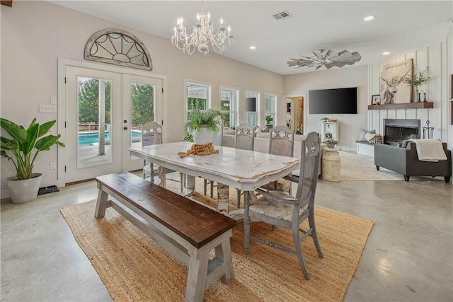 dining area featuring visible vents, concrete flooring, french doors, and an inviting chandelier