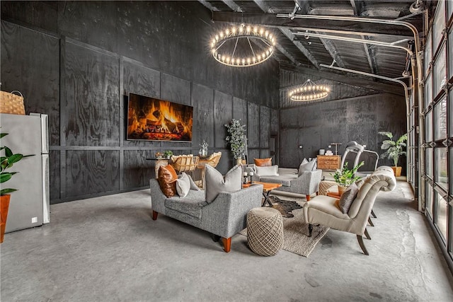 interior space featuring concrete floors, a high ceiling, and a notable chandelier