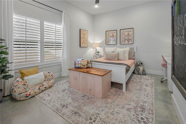 bedroom featuring baseboards, concrete flooring, and recessed lighting