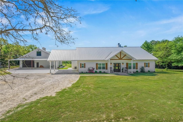 back of property featuring a yard, a chimney, metal roof, and dirt driveway