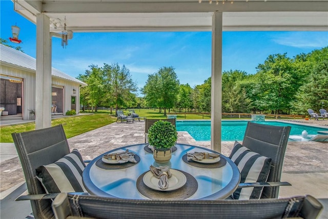 view of patio / terrace featuring outdoor dining area and an outdoor pool