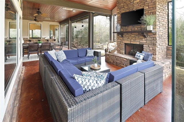 interior space with ceiling fan, lofted ceiling, wood ceiling, and an outdoor stone fireplace