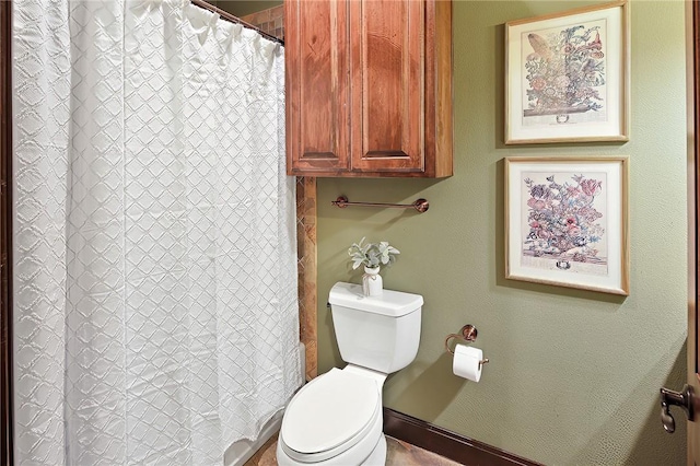 bathroom featuring toilet and curtained shower