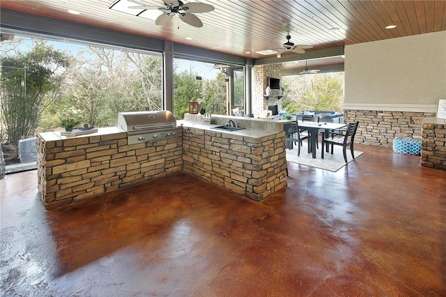 view of patio featuring ceiling fan, a grill, exterior kitchen, sink, and an outdoor stone fireplace