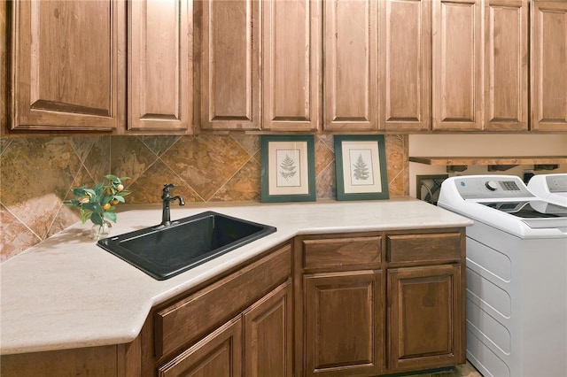 laundry area with sink, separate washer and dryer, and cabinets