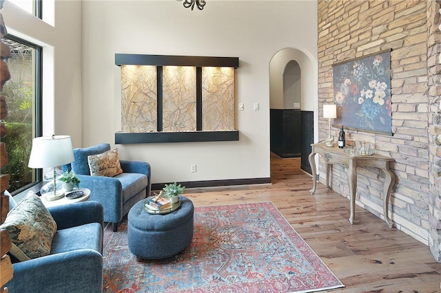 living room featuring light wood-type flooring and a high ceiling