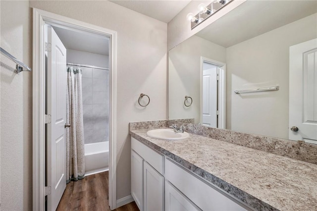 bathroom featuring hardwood / wood-style flooring, vanity, and shower / bath combination with curtain