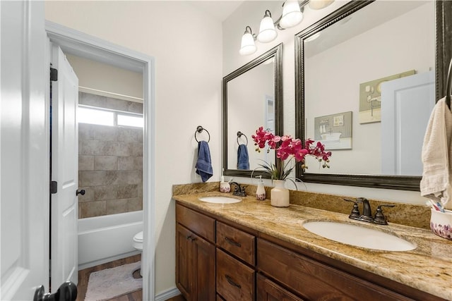 full bath with double vanity, toilet,  shower combination, and a sink