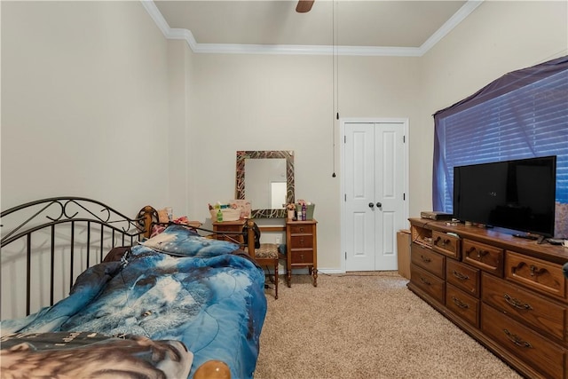 bedroom featuring crown molding, ceiling fan, a closet, and light colored carpet