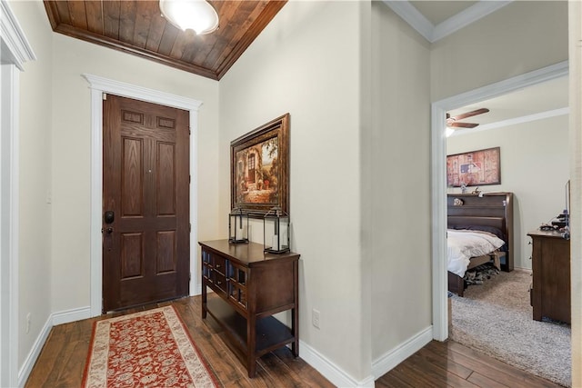 entryway with wood ceiling, dark wood-style flooring, crown molding, and baseboards