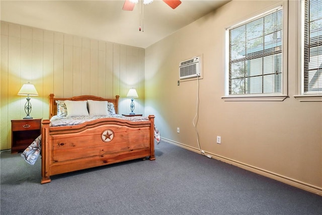 bedroom with dark colored carpet, ceiling fan, wood walls, and a wall unit AC