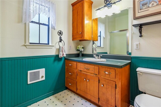 bathroom featuring vanity, toilet, and a shower with shower door