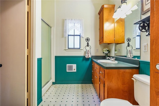 bathroom featuring vanity, toilet, and a shower with door