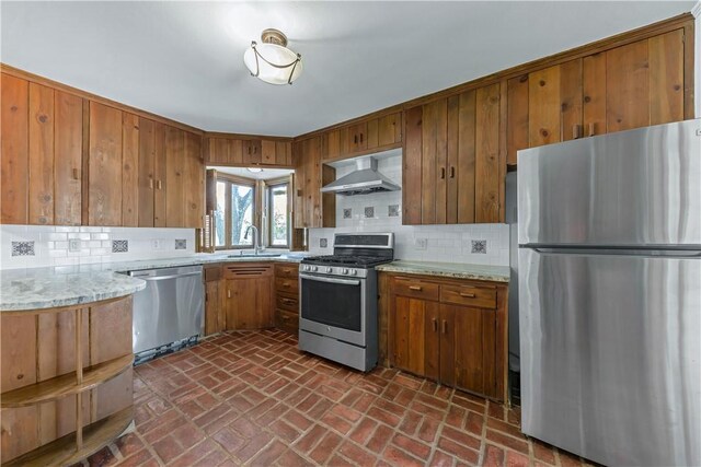 107 E N Ave, Bryan, TX 77801 - kitchen with appliances with stainless steel finishes, ventilation hood, a sink, brown cabinetry, and brick floors