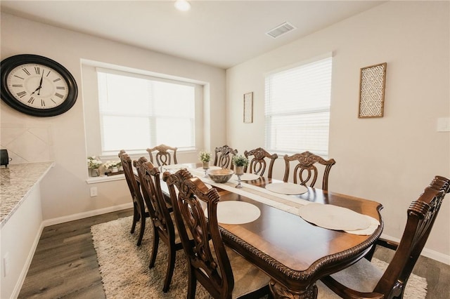 dining area with plenty of natural light, baseboards, visible vents, and dark wood-style flooring